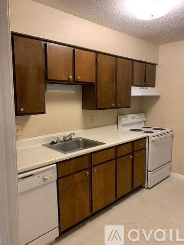 A kitchen with wooden cabinets and white appliances.