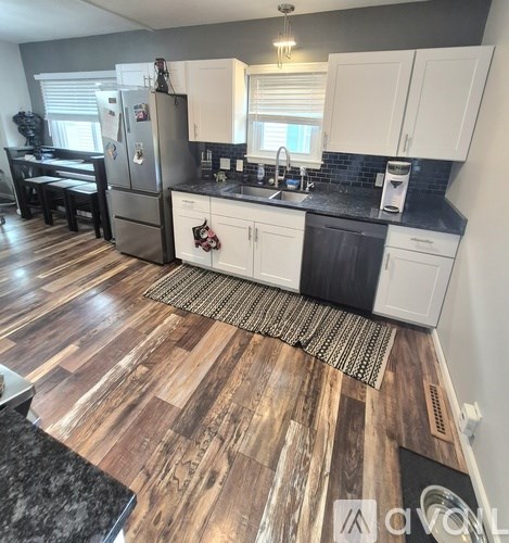A kitchen with white cabinets and a black countertop.