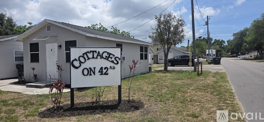 A sign in front of a house that says "Cottages on 42".