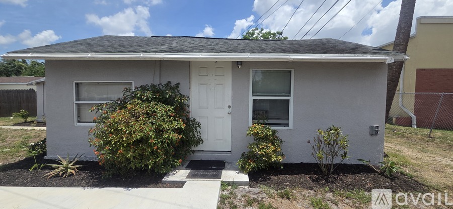A small house with a white door and a window is for sale.