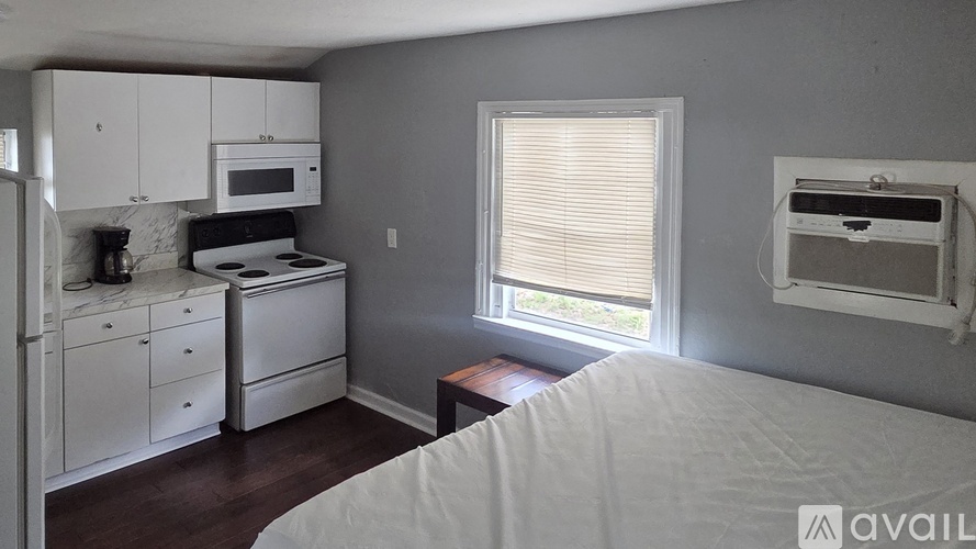 A kitchen with white appliances and cabinets is available for rent.