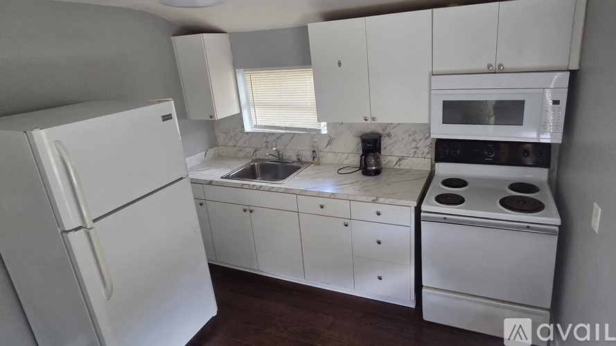 A kitchen with white appliances and cabinets.
