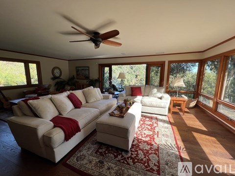 A living room with a white couch and a ceiling fan.