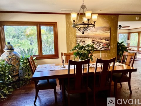 A dining room with a wooden table and chairs.