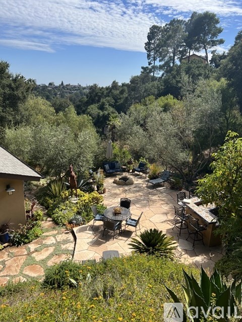 A backyard with a table and chairs surrounded by trees.