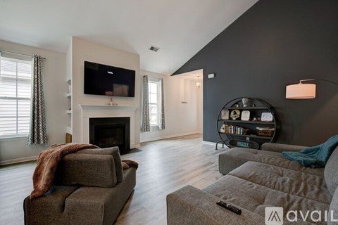 A living room with a grey couch and a fireplace.