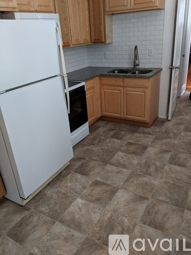 A kitchen with a white refrigerator and a black oven.