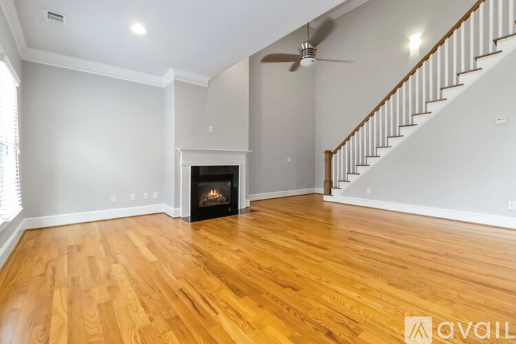 A living room with a wood floor and a fireplace.