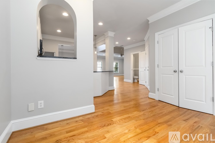 A spacious room with wooden floors and white walls.