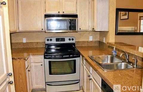 A kitchen with a stove, microwave, and sink.