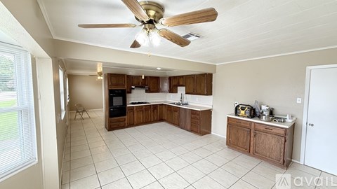 A kitchen with a fan and a window.