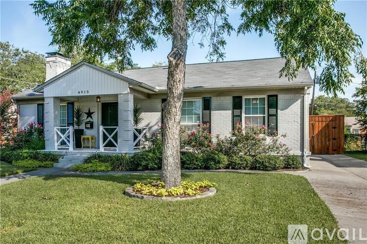 A house with a white front porch and a tree in front.