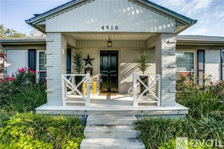 A white house with a black door and a star decoration on the window.