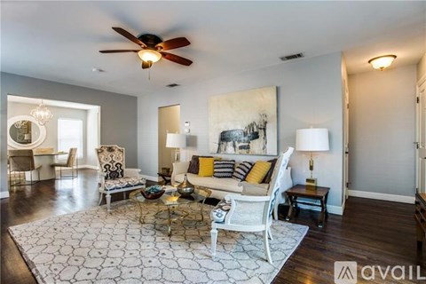 A living room with a white couch and a rug.