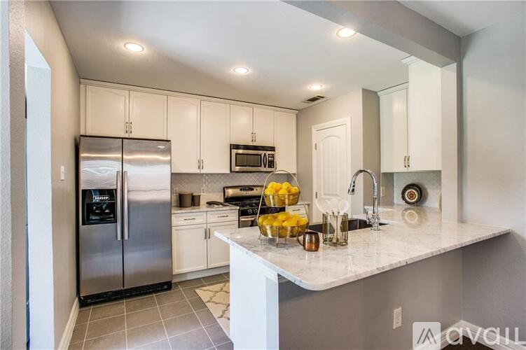 A kitchen with a stainless steel refrigerator and a white countertop.