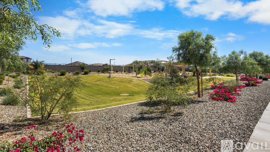 A gravel path leads through a landscaped yard with a variety of plants and trees.