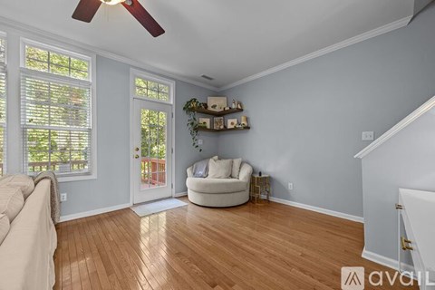 A living room with a white couch and a ceiling fan.