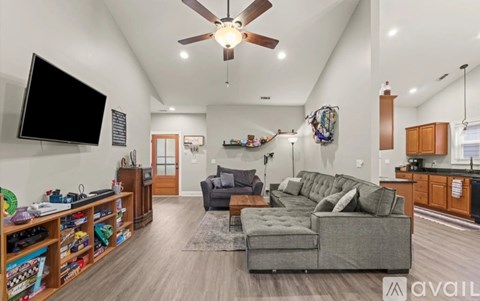 A living room with a grey couch and a television on the wall.