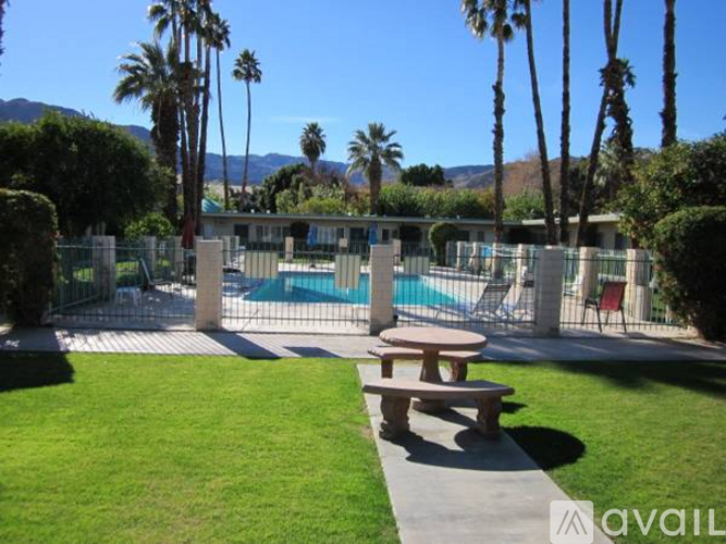 A backyard with a picnic table and a pool.