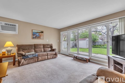 A living room with a brown couch and a painting on the wall.