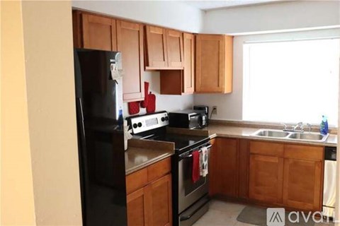 A kitchen with wooden cabinets and black appliances.