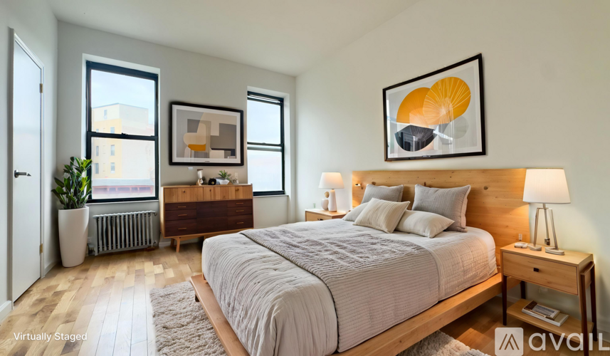 A bedroom with a large bed, a nightstand, and a window.