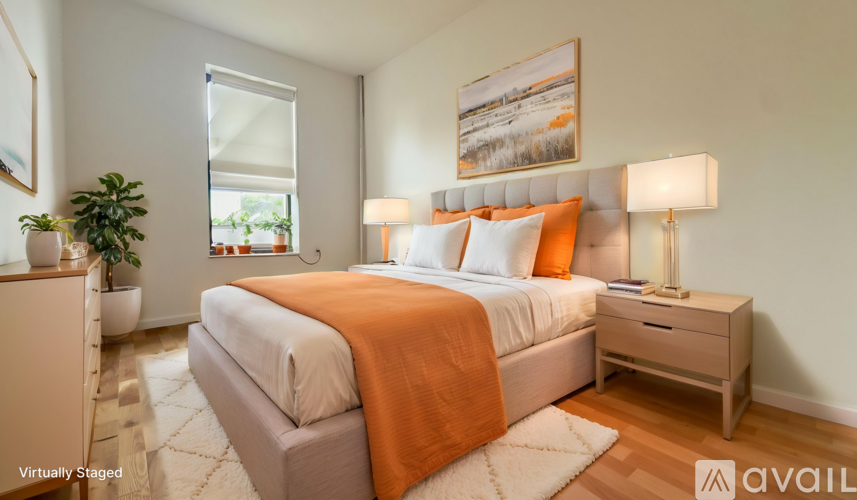 A bedroom with a bed, nightstand, and lamp.