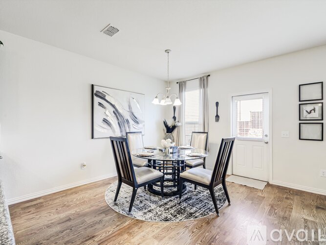 A dining room with a round table and chairs.