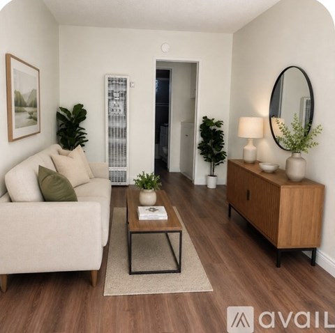 A living room with a white couch, a wooden cabinet, and a coffee table.