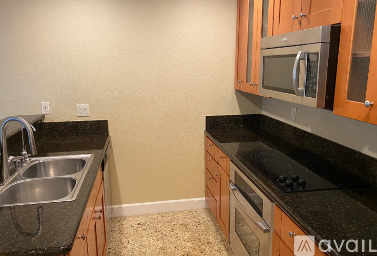 A kitchen with a black countertop and wooden cabinets.