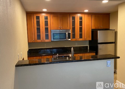 A kitchen with wooden cabinets and black countertops.