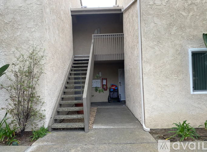 A concrete staircase leads to a balcony on the second floor of a building.