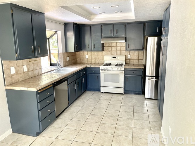 A kitchen with black cabinets and a white stove top oven.