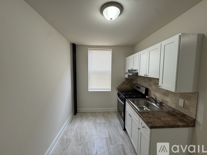 A kitchen with white cabinets and a brown countertop.