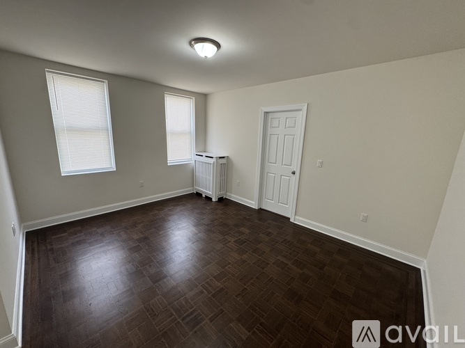 A room with wooden flooring and white walls.