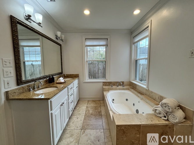 A kitchen with white cabinets and a wooden floor.
