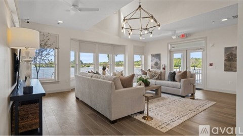 A well-lit living room with a large window view and a sofa set.