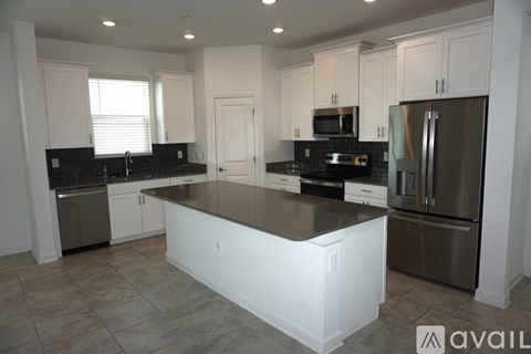 A kitchen with white cabinets and a black countertop.
