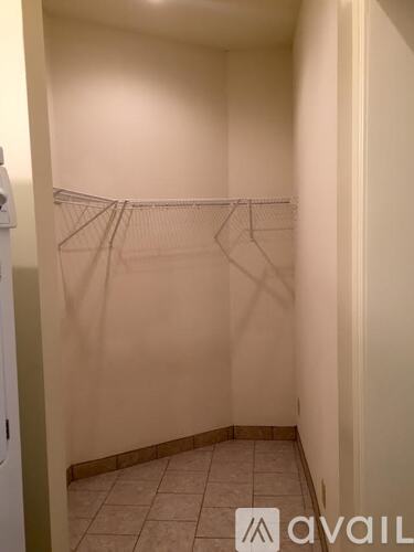 A small, empty room with a coat rack and a tiled floor.