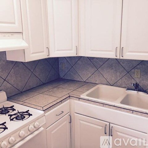 A kitchen with white cabinets and a tiled floor.