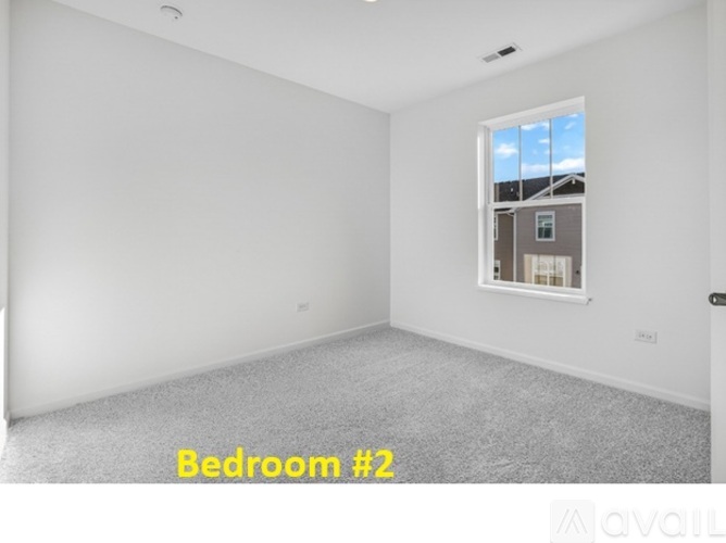 A bedroom with a window and a carpeted floor.