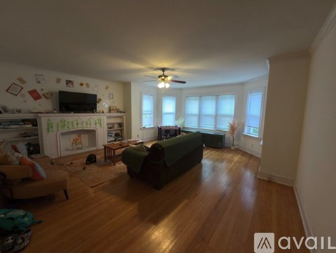 A living room with a green couch and a television on the wall.