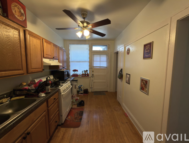 A kitchen with wooden cabinets and a fan on the ceiling.