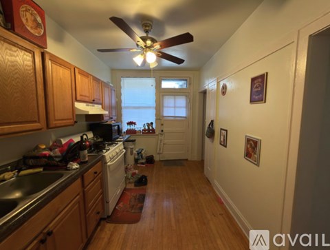 A kitchen with wooden cabinets and a fan on the ceiling.