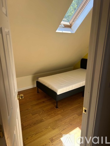 A bedroom with a bed and a skylight.