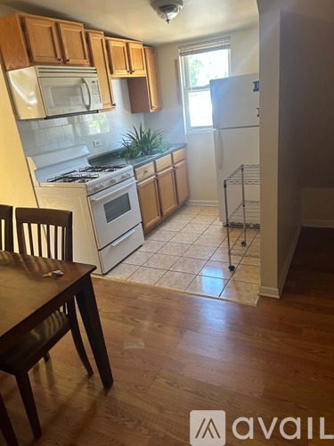 A kitchen with wooden floors and white appliances.