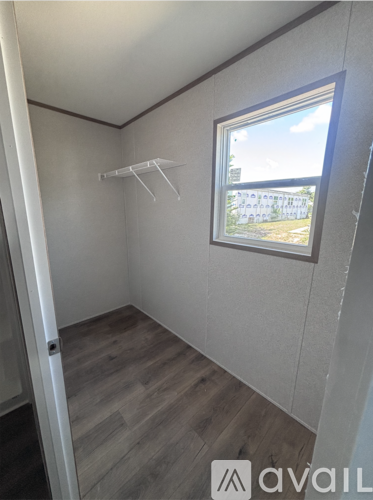 A room with a window and a wooden floor.
