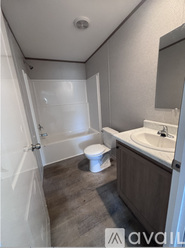 A bathroom with a toilet, sink, and bathtub.