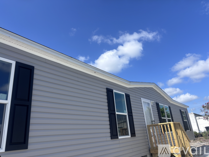 A house with a grey siding and a yellow railing.