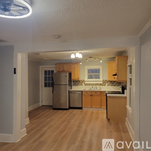 A kitchen with wooden cabinets and a refrigerator.